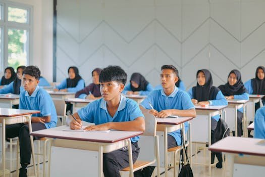 High school students in uniform attentively studying in an Indonesian classroom.